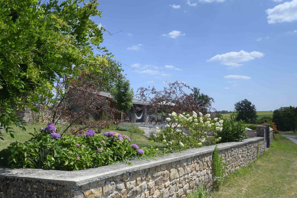 Garden with mature trees and hydrangeas at La Terrade